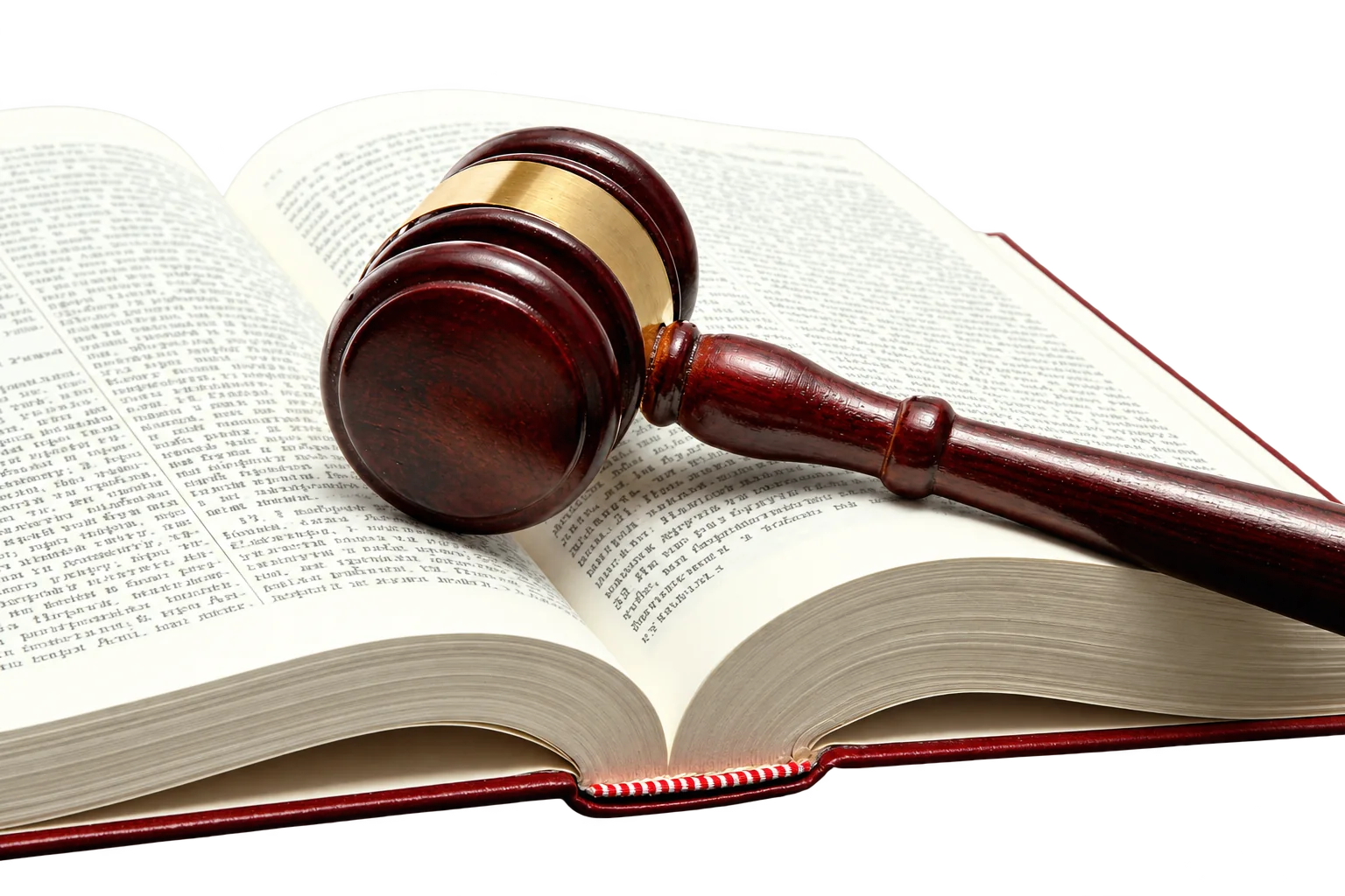 Un marteau de juge en bois sombre à bague dorée repose sur un gros livre ouvert.